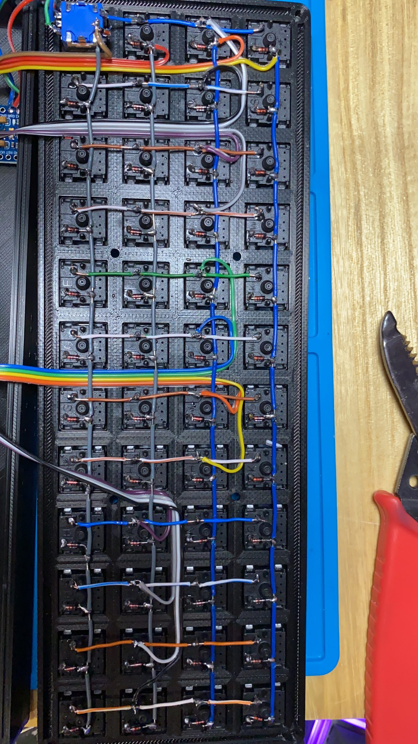 A picture from the back of the keyboard, showing the wired matrix and the link wires routed and connected ready for the microcontroller.