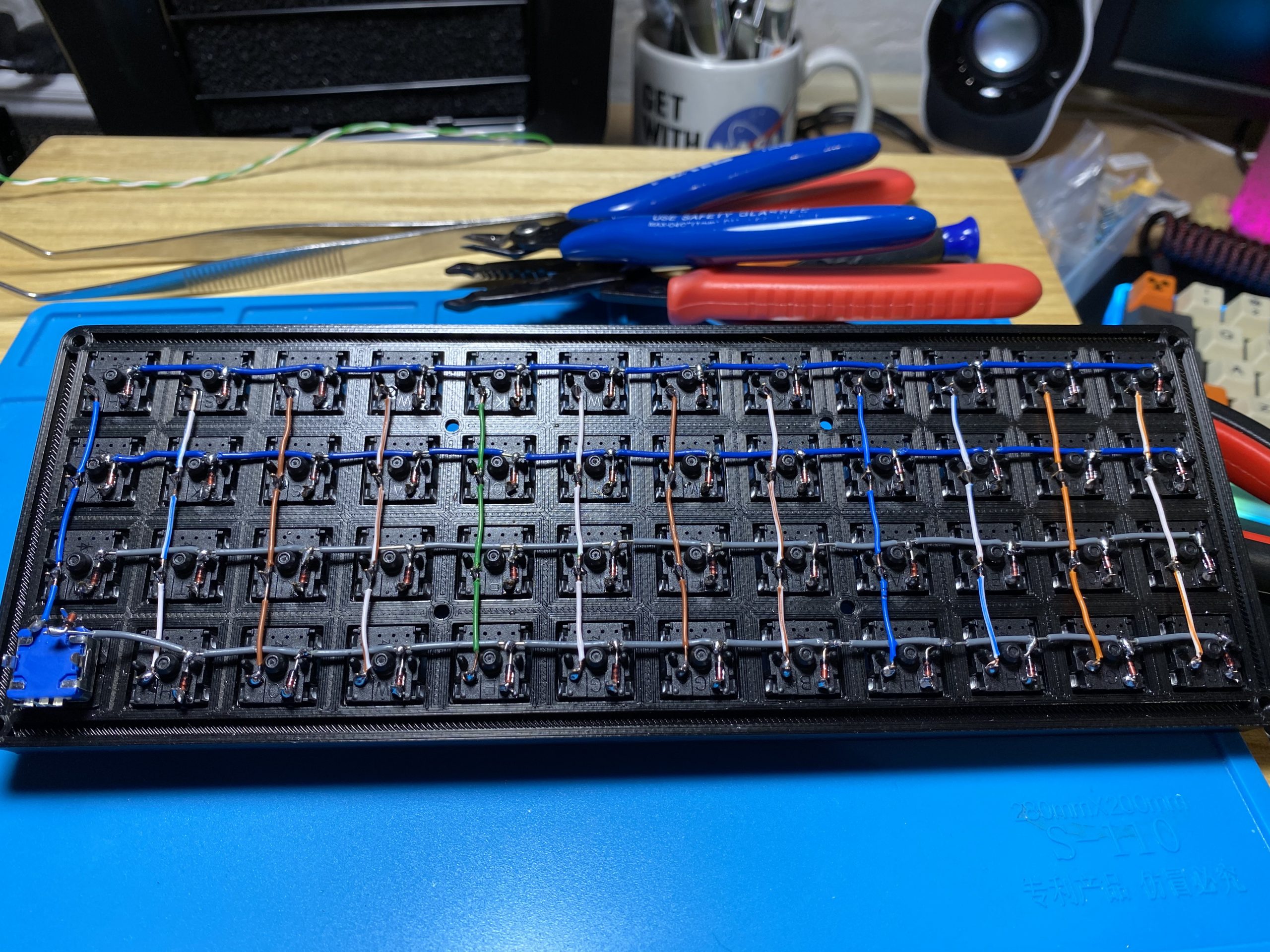 A continuing from the previous picture of a 3d printed keyboard, there are now connections uisng wire between each column of the siwtches making a maxtrix.