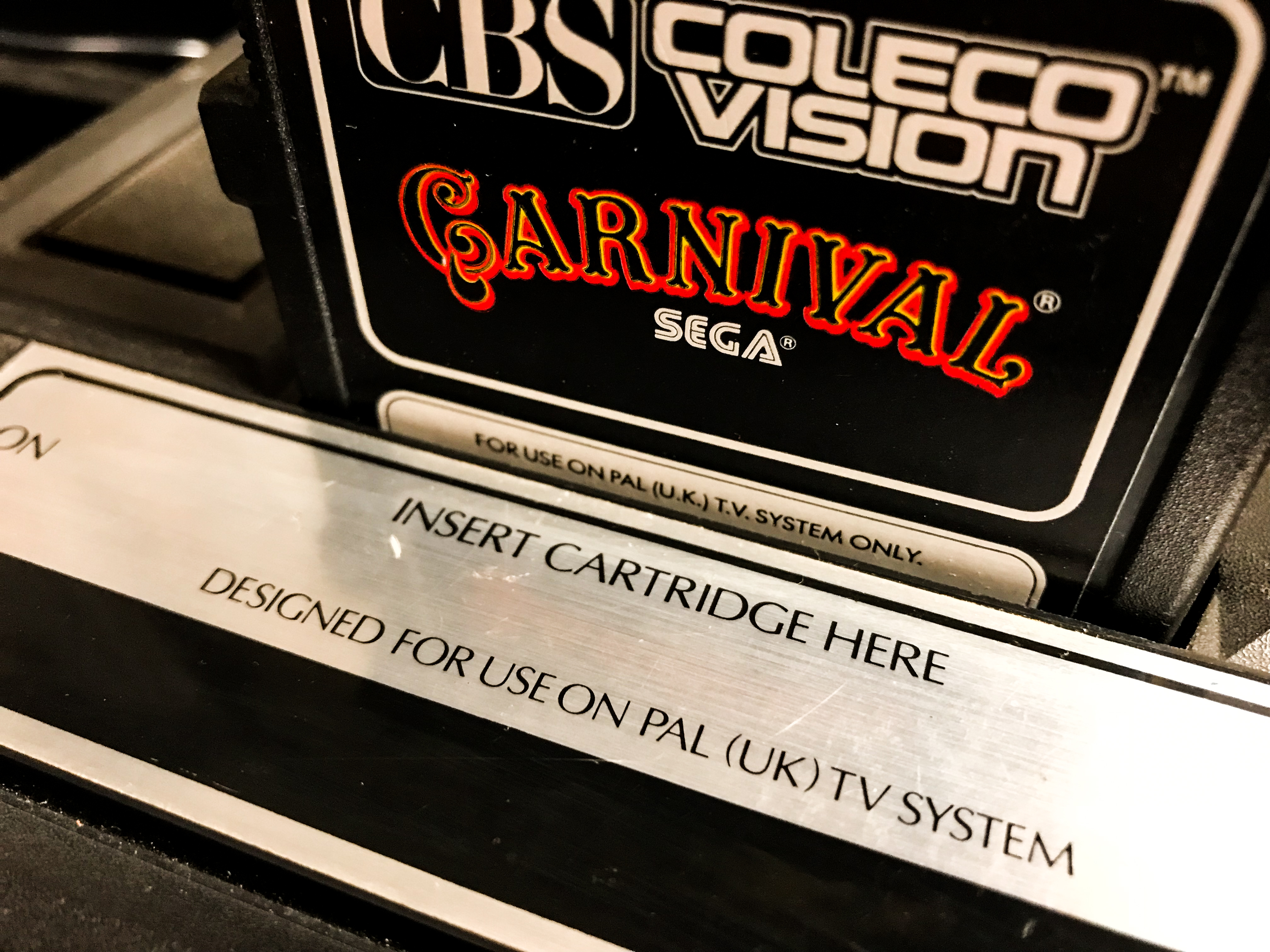 A close up shot of a ColecoVision cartridge slot with the game Carnival in it. 